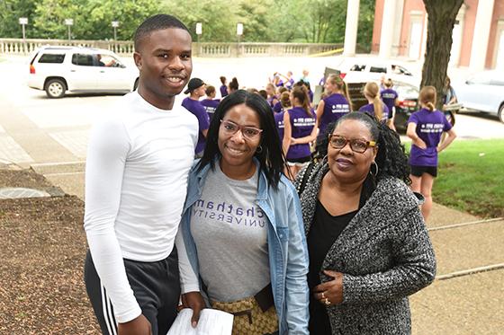 Photo of a Chatham University student posing outside with her mom and brother on family weekend. 